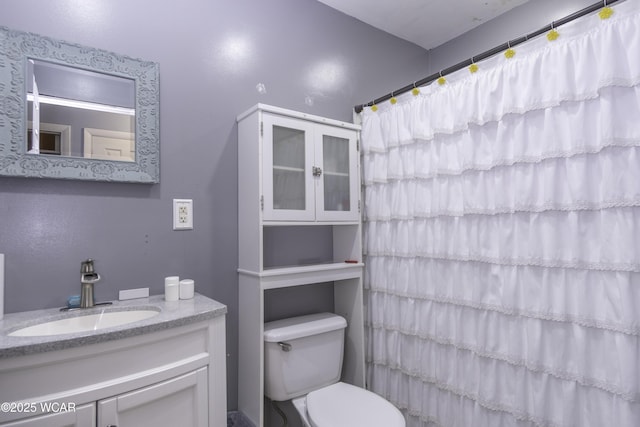 bathroom with toilet, a shower with shower curtain, and vanity