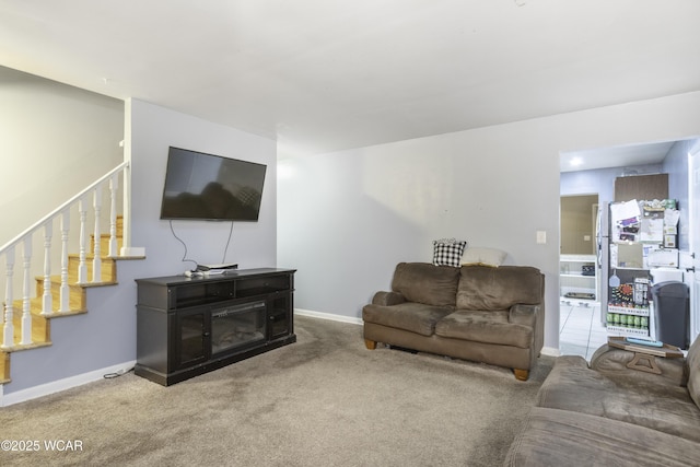 carpeted living room featuring baseboards and stairway