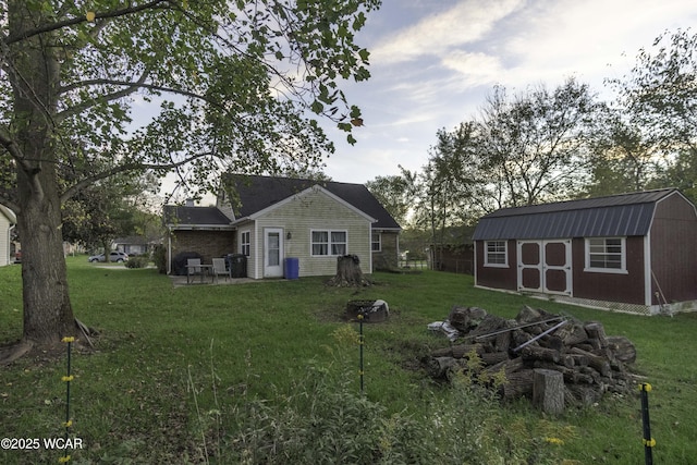 exterior space with a yard, an outdoor structure, a gambrel roof, and a storage shed