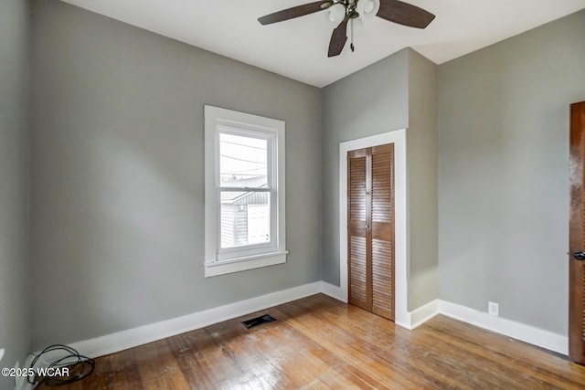 unfurnished bedroom with ceiling fan, hardwood / wood-style floors, and a closet