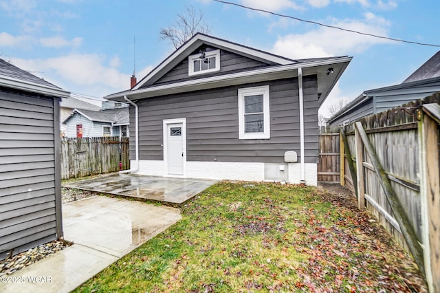 rear view of property with a yard and a patio