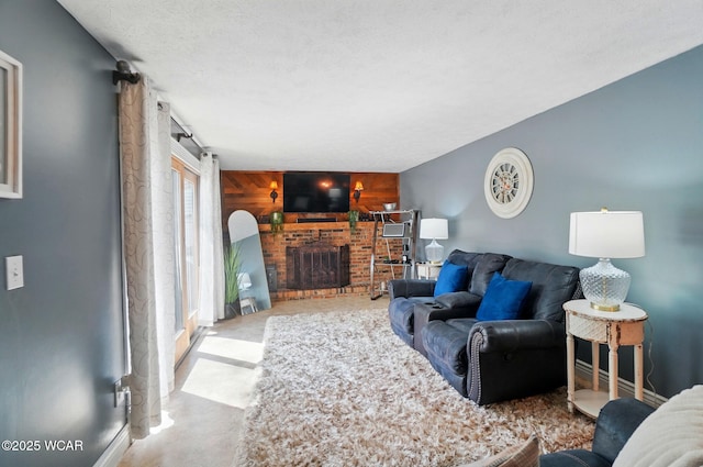 living room with baseboards, wooden walls, a brick fireplace, concrete floors, and an accent wall