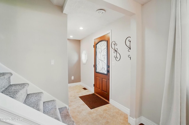 foyer entrance with recessed lighting, light carpet, baseboards, and stairs