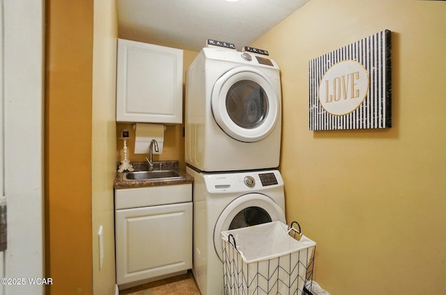 laundry area with a sink, stacked washing maching and dryer, and cabinet space