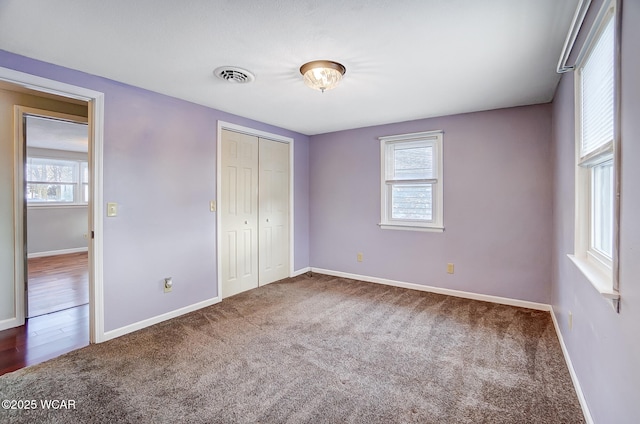 unfurnished bedroom featuring multiple windows, a closet, and carpet