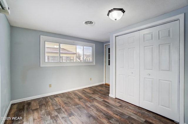 unfurnished bedroom featuring dark wood-type flooring and a closet