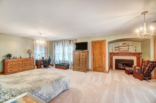 carpeted bedroom featuring a tiled fireplace and a notable chandelier