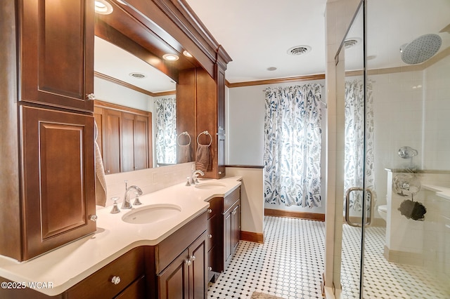 bathroom featuring vanity, crown molding, a shower with shower door, and toilet