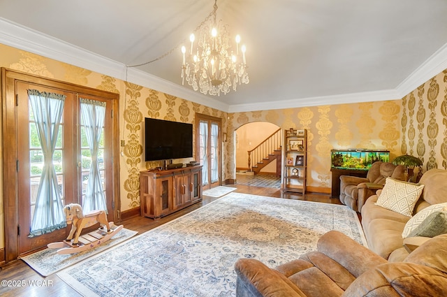 living room featuring crown molding, hardwood / wood-style floors, a chandelier, and french doors