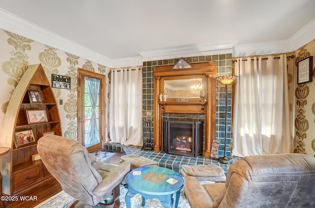 living area with a tile fireplace and crown molding