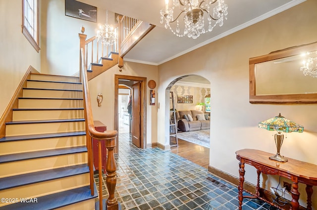 foyer entrance with an inviting chandelier, ornamental molding, and dark hardwood / wood-style floors