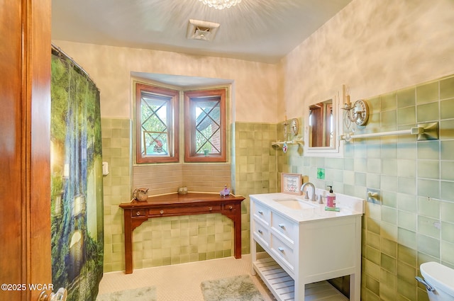 bathroom featuring vanity, tile walls, tile patterned floors, and toilet