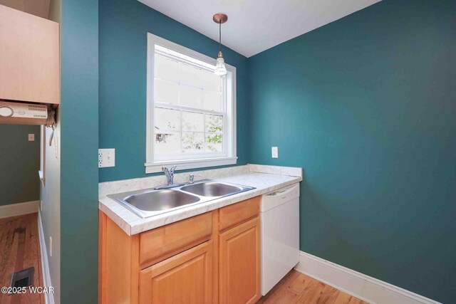 503 N Main St, Bluffton, OH 45817 - kitchen featuring white dishwasher, light wood finished floors, light countertops, and hanging light fixtures