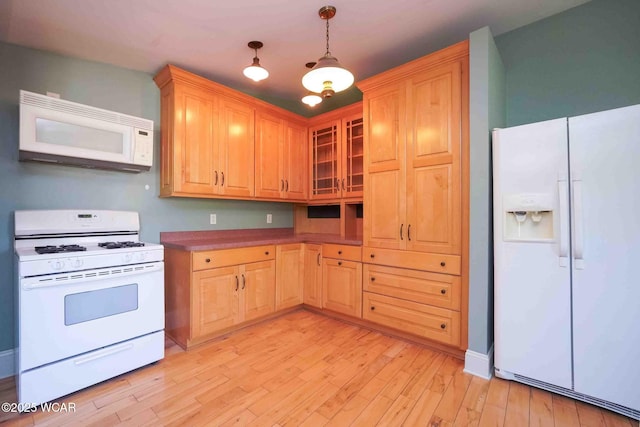 503 N Main St, Bluffton, OH 45817 - kitchen featuring white appliances, light brown cabinets, light wood-style floors, glass insert cabinets, and pendant lighting