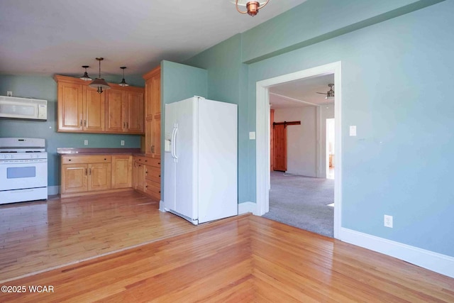 503 N Main St, Bluffton, OH 45817 - kitchen featuring white appliances, light wood-type flooring, and hanging light fixtures
