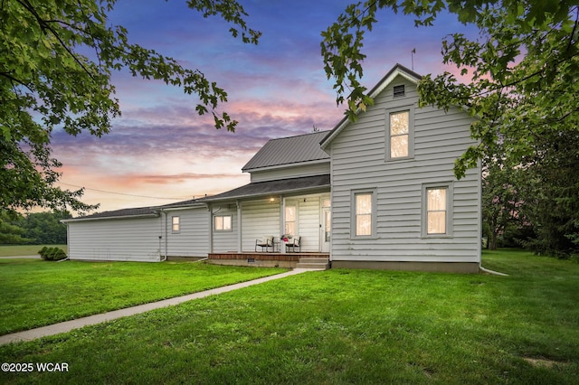 6250 Kreischer Rd, Van Wert, OH 45891 - back of property at dusk with a porch, a yard, and a metal roof