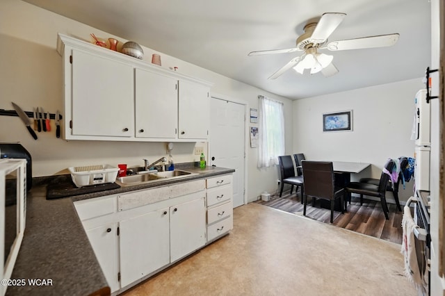 605 Hendricks Ave, Saint Marys, OH 45885 - kitchen featuring a sink, a ceiling fan, white cabinetry, and dark countertops