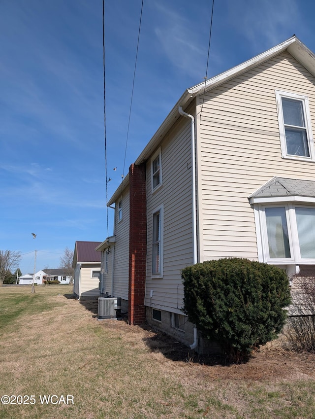 217 Center St, Vaughnsville, OH 45893 - view of property exterior featuring a lawn and central AC