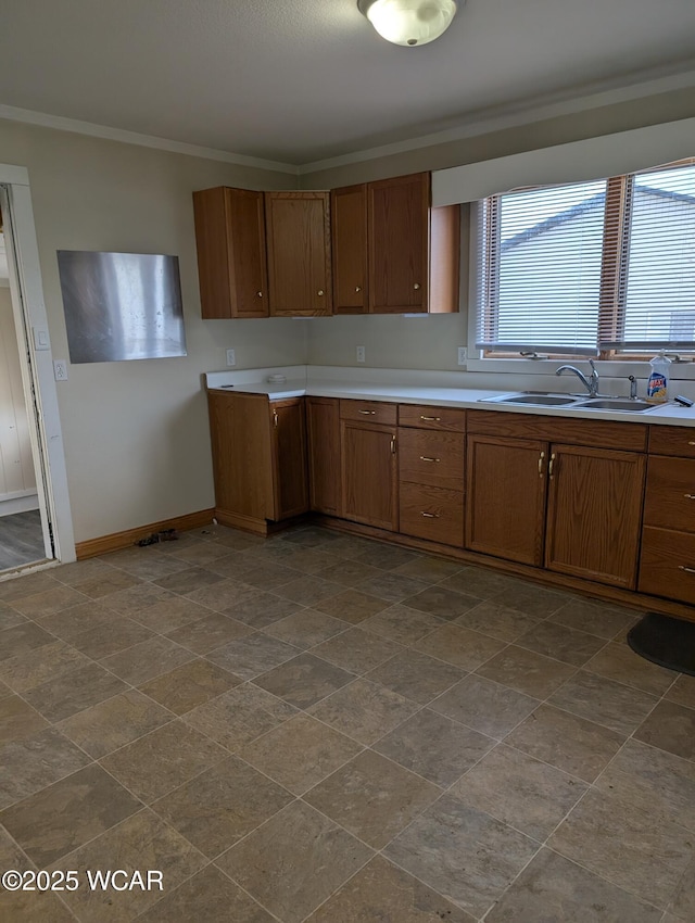 217 Center St, Vaughnsville, OH 45893 - kitchen featuring crown molding, baseboards, light countertops, brown cabinetry, and a sink