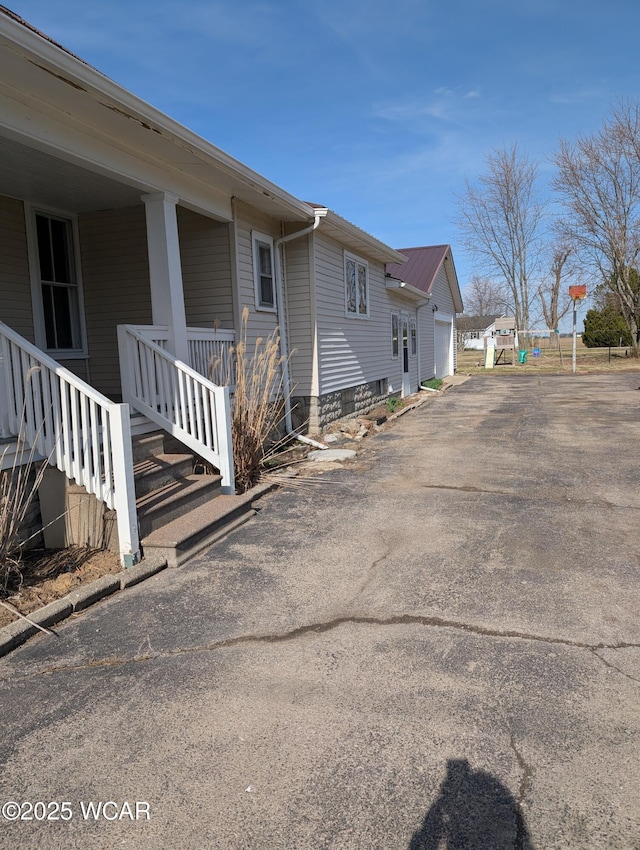 217 Center St, Vaughnsville, OH 45893 - view of home's exterior featuring aphalt driveway, a garage, and covered porch