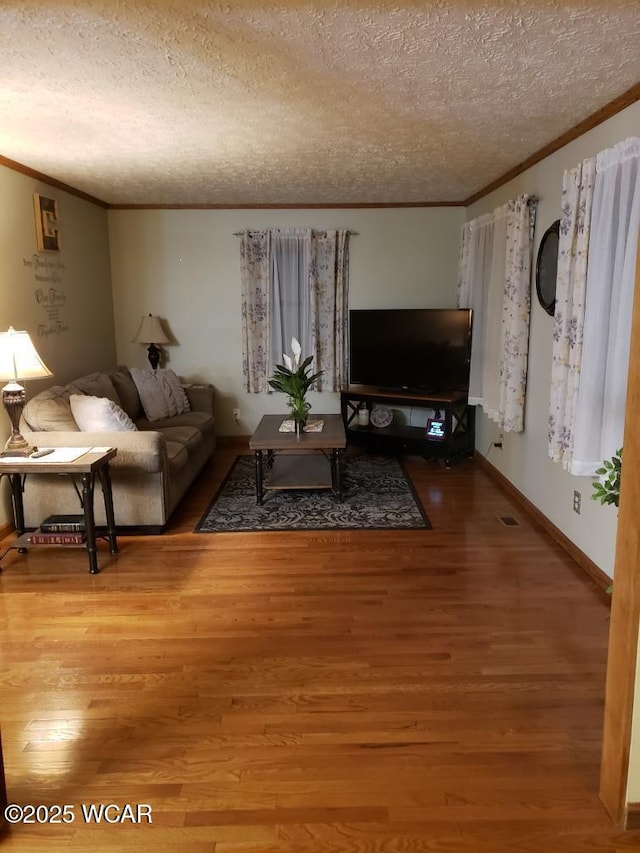 living room with crown molding, hardwood / wood-style flooring, and a textured ceiling