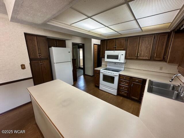 1317 Timberlane Dr, Lima, OH 45805 - kitchen with white appliances, dark wood finished floors, dark brown cabinetry, light countertops, and a peninsula