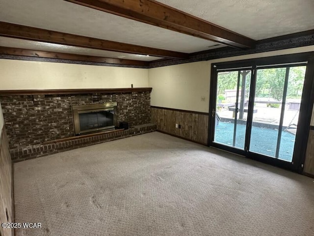 1317 Timberlane Dr, Lima, OH 45805 - unfurnished living room featuring a wainscoted wall, beamed ceiling, carpet flooring, wood walls, and a fireplace