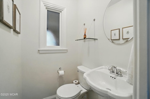bathroom with baseboards, a sink, and toilet