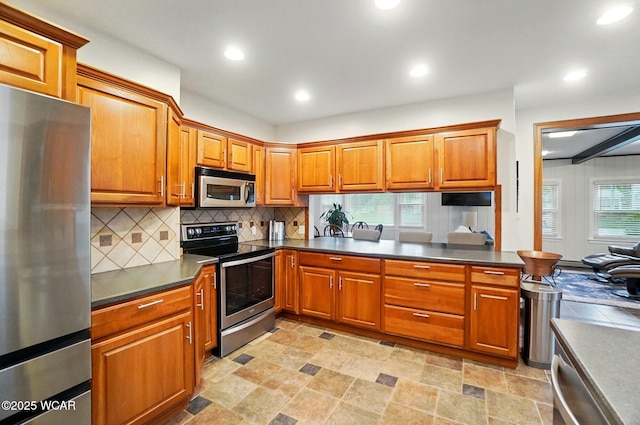kitchen with dark countertops, appliances with stainless steel finishes, and brown cabinets