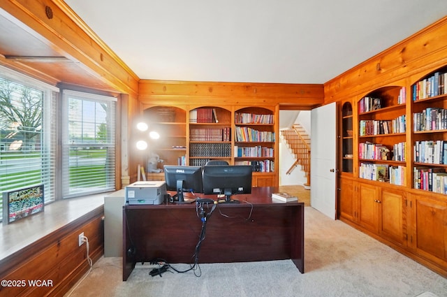 home office with wooden walls, crown molding, light carpet, and built in shelves