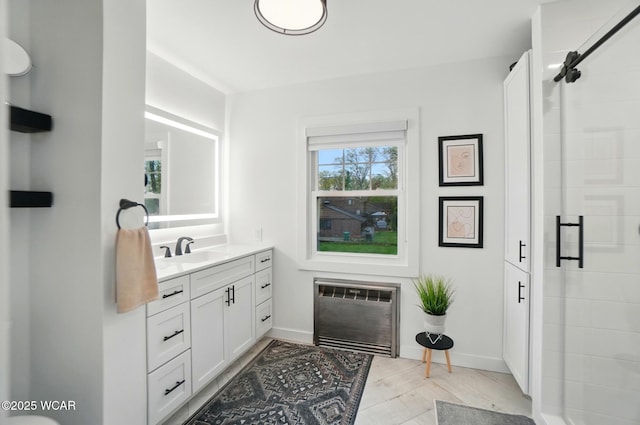 full bath featuring baseboards, heating unit, a shower stall, and vanity