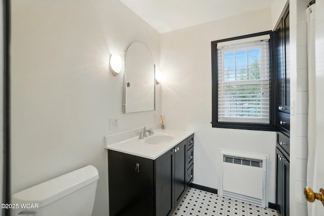 bathroom with radiator, baseboards, vanity, and toilet