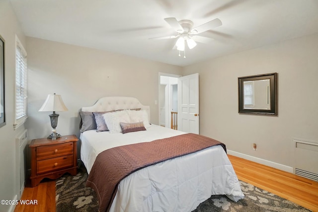 bedroom featuring a ceiling fan, baseboards, and wood finished floors
