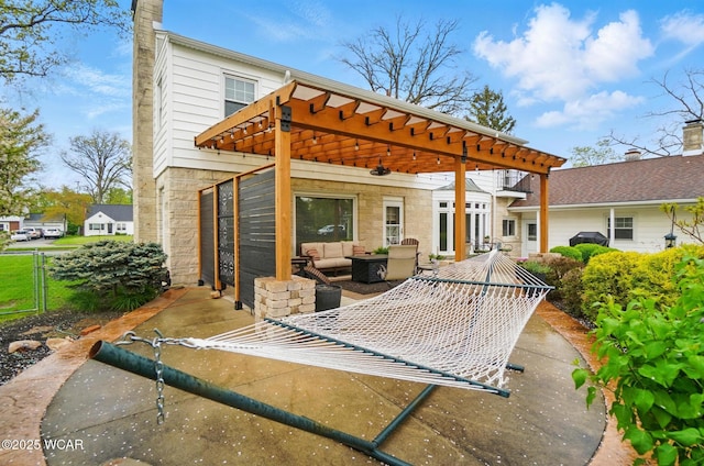 back of house featuring an outdoor living space, a patio area, a pergola, and stone siding