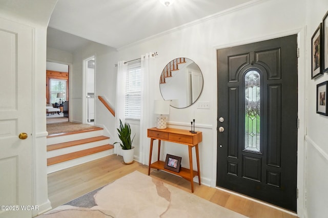 foyer featuring baseboards, stairs, and wood finished floors