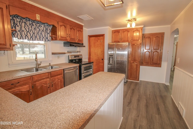 kitchen with ornamental molding, appliances with stainless steel finishes, sink, and dark wood-type flooring