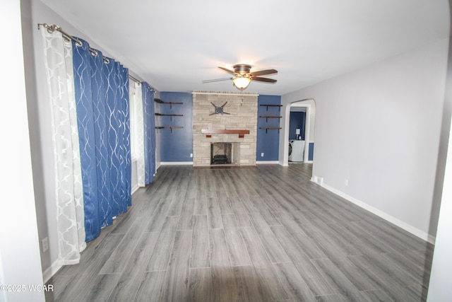 unfurnished living room featuring ceiling fan, a fireplace, and wood-type flooring