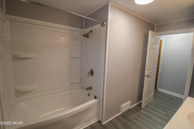 bathroom featuring ornamental molding, hardwood / wood-style floors, and shower / bathing tub combination