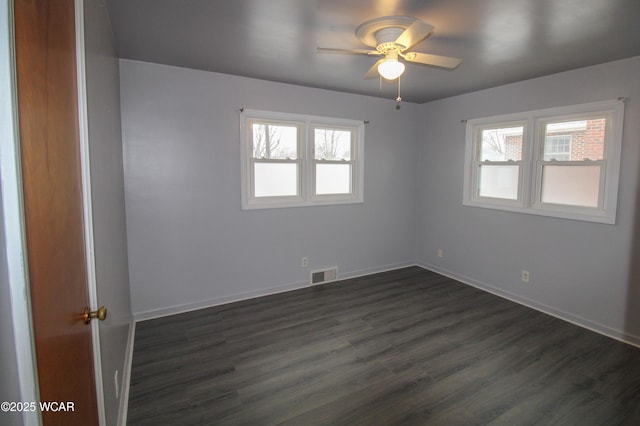 spare room with dark wood-type flooring, ceiling fan, and plenty of natural light