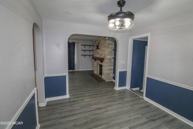 unfurnished dining area with dark hardwood / wood-style flooring and a stone fireplace