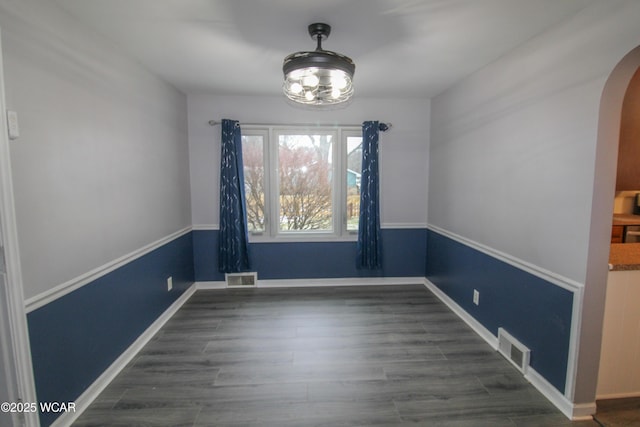 unfurnished dining area featuring dark wood-type flooring