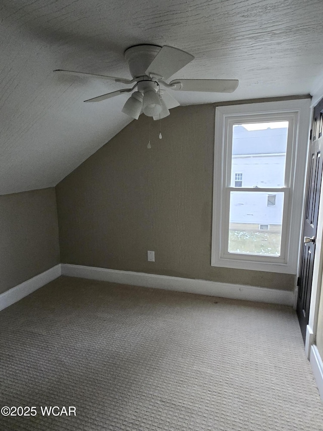 bonus room featuring lofted ceiling, a textured ceiling, carpet, and ceiling fan