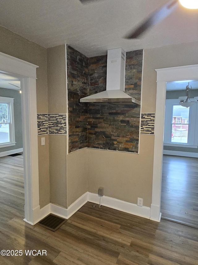 interior space featuring dark hardwood / wood-style floors and wall chimney exhaust hood