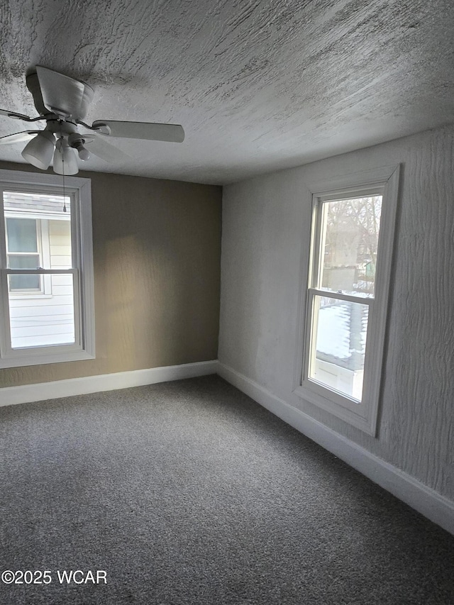 unfurnished room with ceiling fan, plenty of natural light, carpet floors, and a textured ceiling