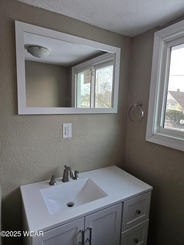 bathroom with vanity, plenty of natural light, and a textured ceiling