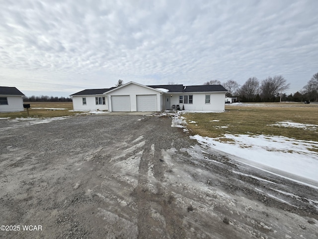 view of front of home with driveway, an attached garage, and a lawn