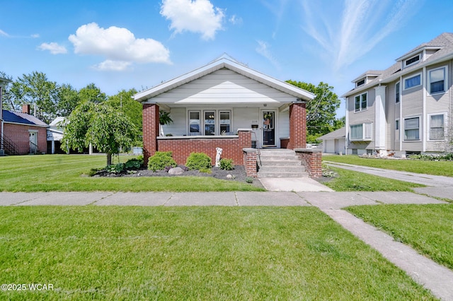219 N Market St, Kenton, OH 43326 - view of front of home featuring brick siding, a front lawn, and a porch