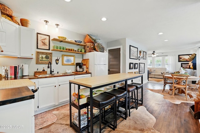 219 N Market St, Kenton, OH 43326 - kitchen with a sink, freestanding refrigerator, wood counters, recessed lighting, and white cabinetry