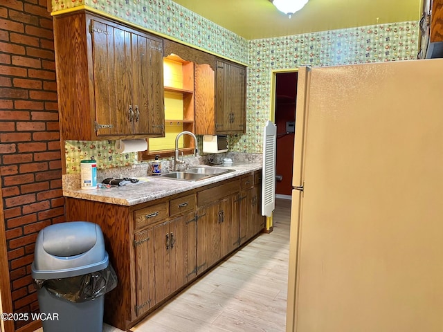 1440 Southwood Dr, Lima, OH 45805 - kitchen featuring freestanding refrigerator, a sink, light wood-type flooring, wallpapered walls, and light countertops