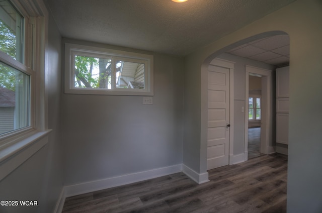 430 Hazel Ave, Lima, OH 45801 - empty room featuring arched walkways, dark wood-type flooring, baseboards, and a textured ceiling